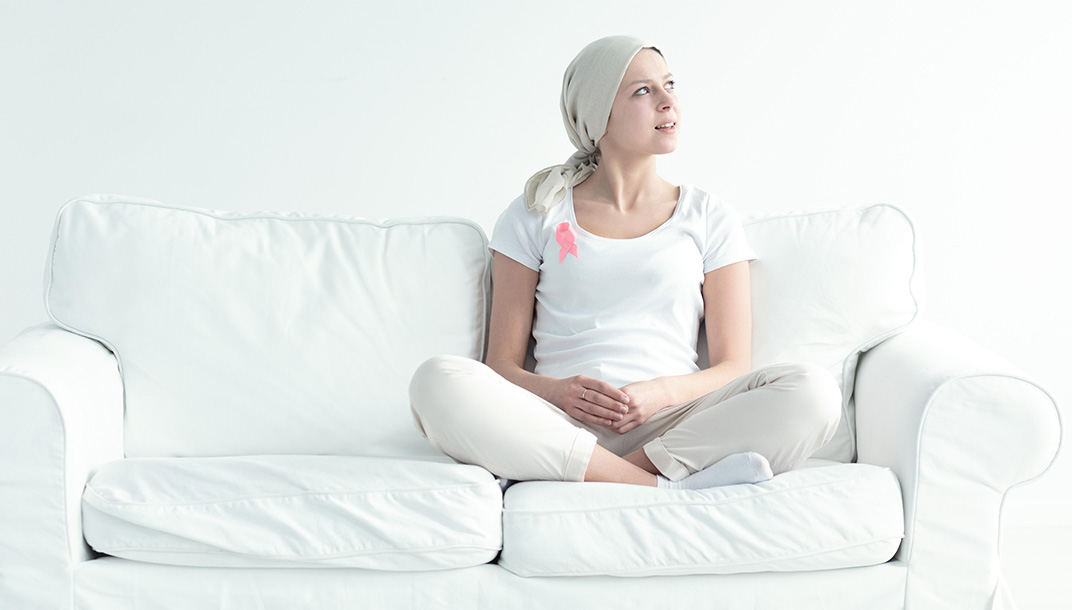 woman-sits-couch-with-cancer